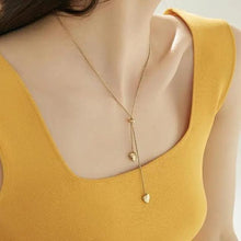 Load image into Gallery viewer, Model wearing gold lariat double heart necklace, highlighting its elegance.

