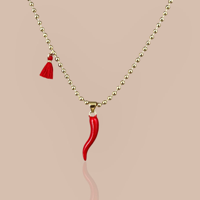 Red Cornicello pendant on an 18k gold-plated chain, close-up.