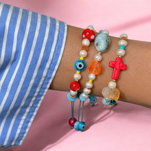 Load image into Gallery viewer, Model wearing colorful bracelet stacked with other jewelry.
