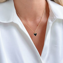 Load image into Gallery viewer, Close-up of Black Enamel Heart Necklace on a gold-plated chain. Stylish and elegant jewelry piece, perfect for everyday wear or special occasions.
