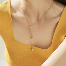 Load image into Gallery viewer, Model wearing gold lariat double heart necklace, highlighting its elegance.

