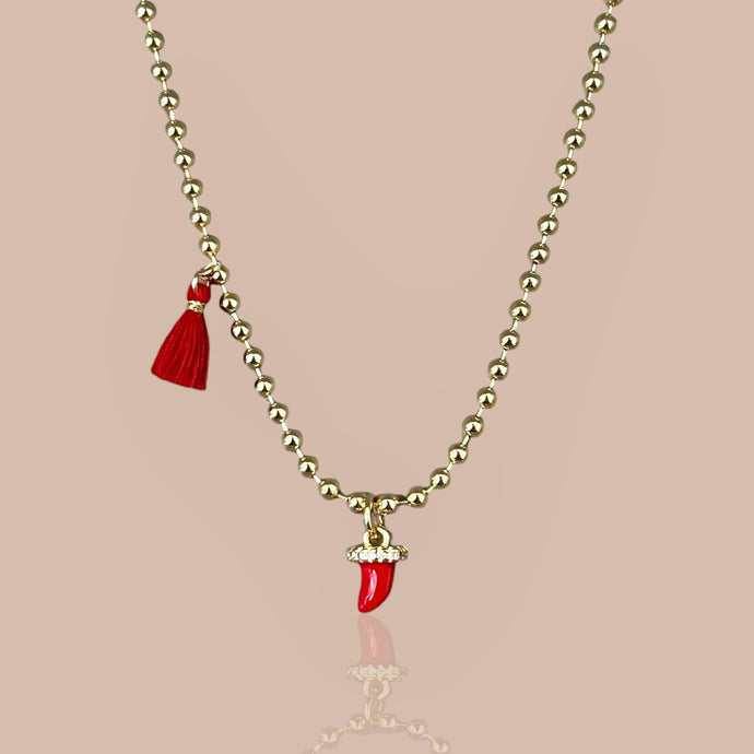 Red Cornicello pendant on an 18k gold-plated chain, close-up.