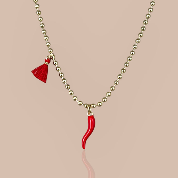 Red Cornicello pendant on an 18k gold-plated chain, close-up.