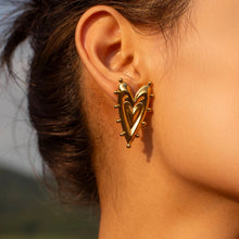 Load image into Gallery viewer, Model wearing large gold heart earrings
