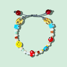 Load image into Gallery viewer, Close-up of colorful beaded bracelet with freshwater pearls, evil eye, mushroom, and smiley face charm.
