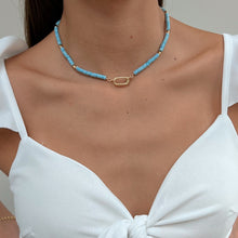 Load image into Gallery viewer, Model wearing Front Clasp Blue Disc Necklace, emphasizing its stylish look and blue disc.
