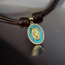 Load image into Gallery viewer, Close-up of gold religious charm set on turquoise stone with CZ accents
