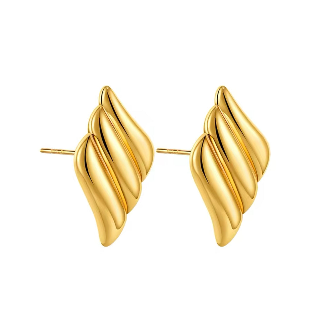 Close-up of statement gold wing earrings with a sleek finish.