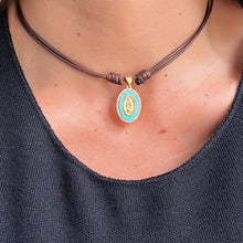 Load image into Gallery viewer, Turquoise Religious Choker Necklace with gold-tone charm on turquoise stone.
